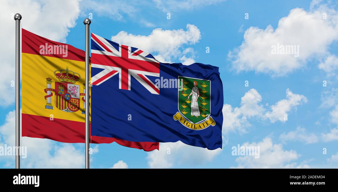 Spanien und British Virgin Inseln Flagge im Wind gegen Weiße bewölkt blauer Himmel zusammen. Diplomatie Konzept, internationale Beziehungen. Stockfoto