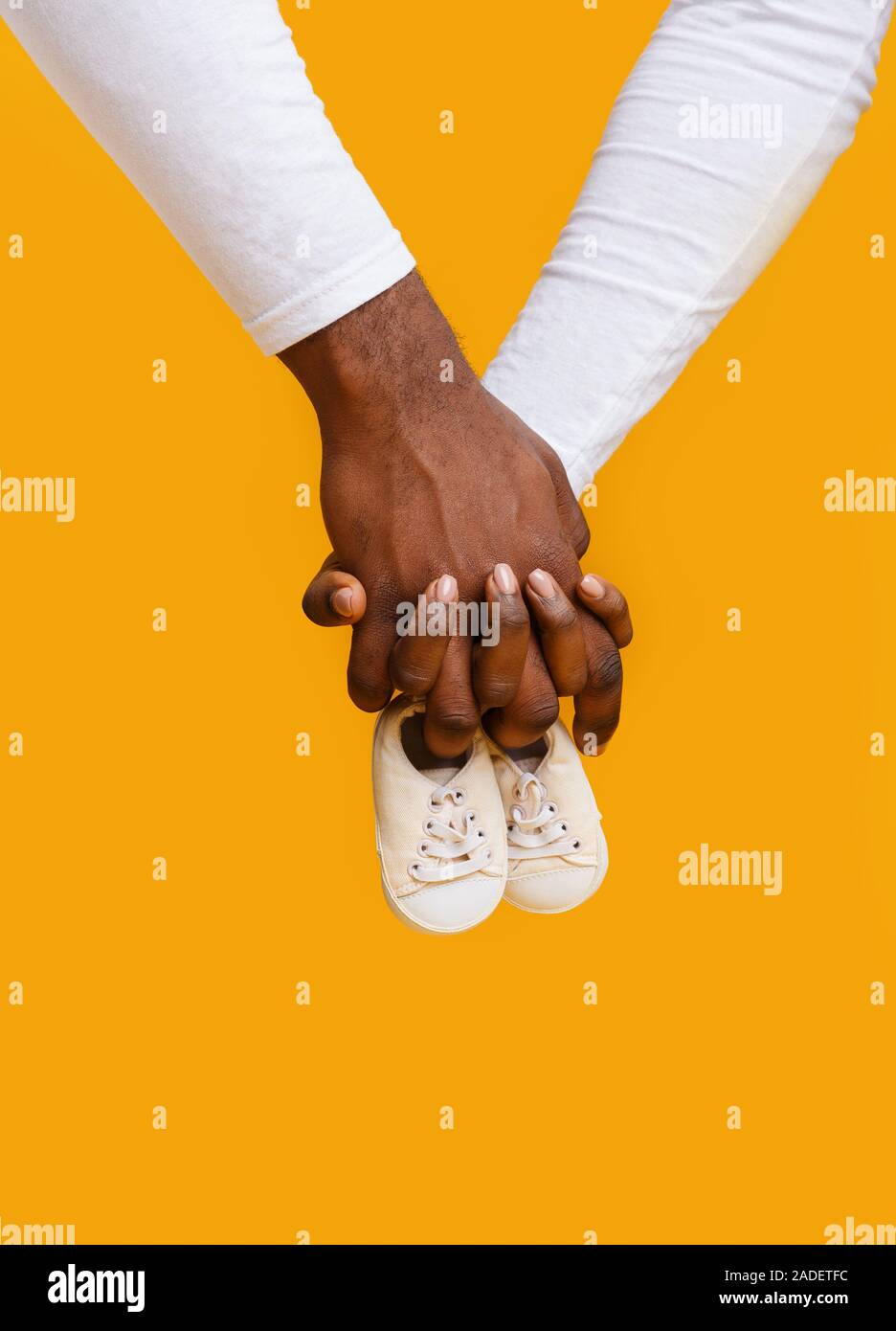 Hände von schwarz Paar hält Baby Stiefel zusammen Stockfoto