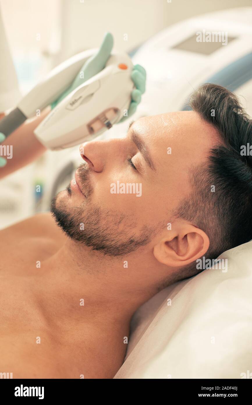 Ruhige Gesicht der Mann auf dem Foto der Verjüngung in der modernen Klinik Stockfoto