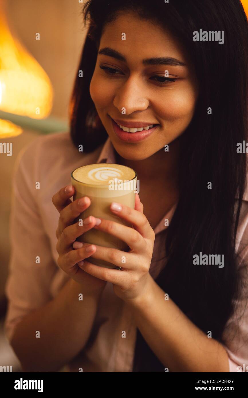 Langhaarige Frau mit Latte in ihre Hände Stockfoto
