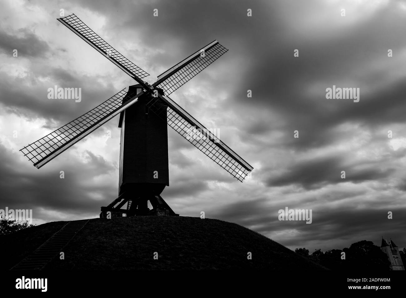 Hoher Kontrast Silhouette der Windmühle, dramatische Himmel. Blick auf die Straße von wunderschönen historischen Stadtzentrum Architektur von Brügge oder Brügge, Provinz Westflandern, Belgien. Schönen Sommer August Wetter Stockfoto