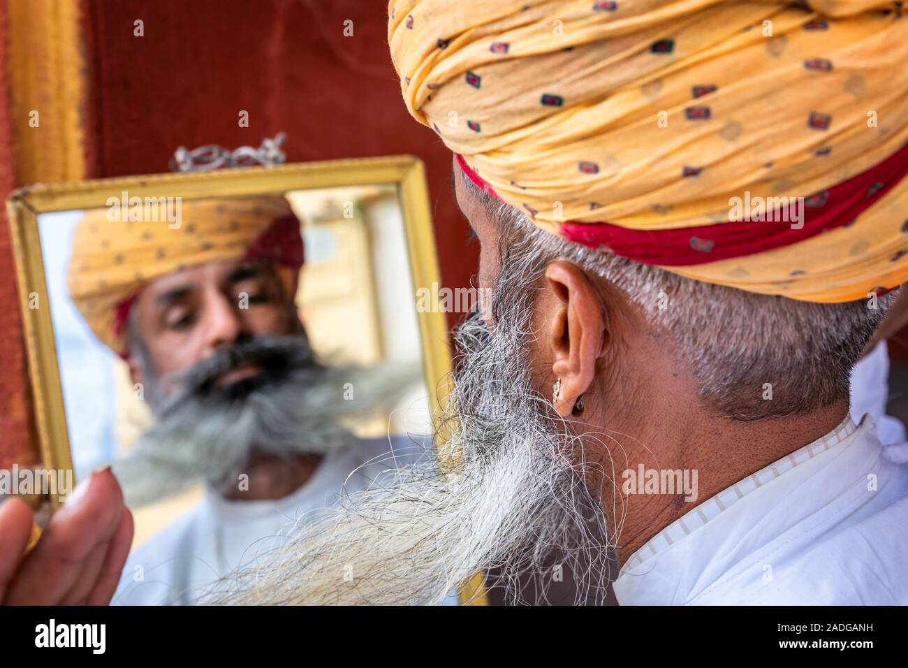 Mann bin auf seine Reflexion in einem Spiegel, wenn seinen Bart zur Festsetzung, Jodhpur, Rajasthan, Indien Stockfoto