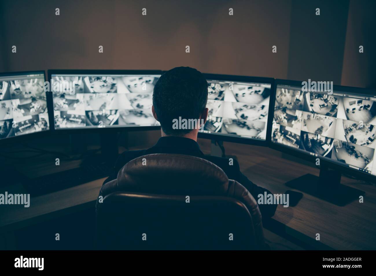 Hintere zurück hinter Ansicht von erfahrenen Mann Spezialist Experte Top Safety Manager überwachung Brandmeldezentrale Nachtschicht Anzeigen mehrerer TV-Fernsehgerät Stockfoto