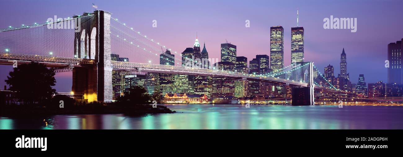 Brücke über einen Fluss leuchtet in der Dämmerung, Brooklyn Bridge, East River, World Trade Center, Wall Street, Manhattan, New York City, New York State, USA Stockfoto