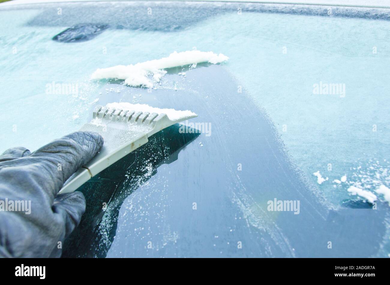 Die Windschutzscheibe eines Autos wird aus dem Eis im Winter kratzten Stockfoto