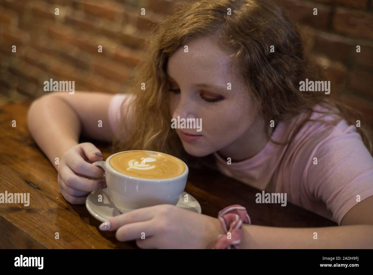 Ein Mädchen auf der Suche auf einen Cappuccino trinken. Stockfoto