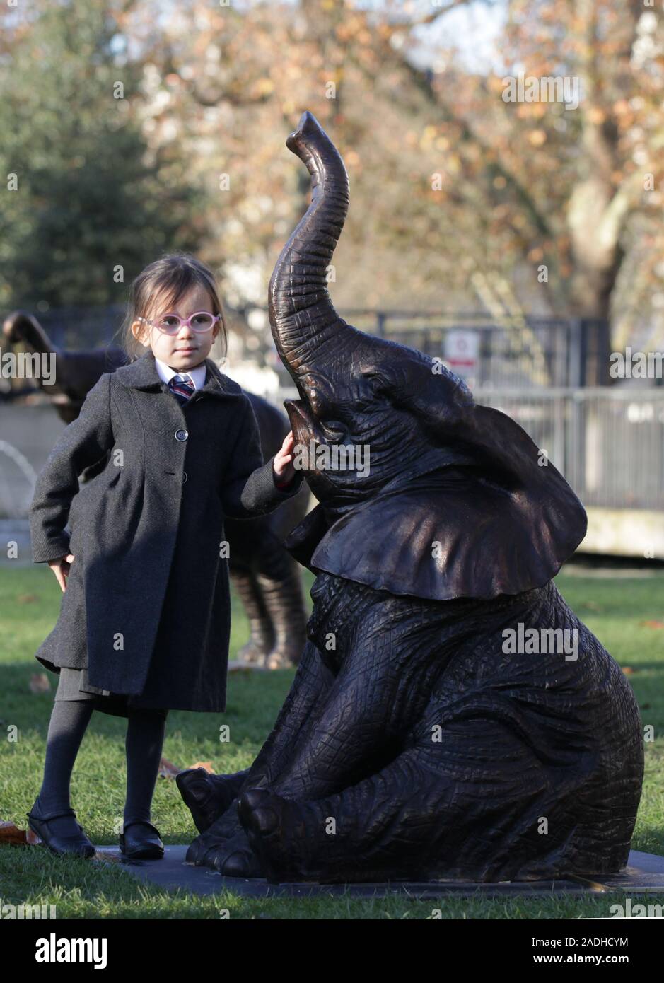 Georgie Chubb, vier, von Hampden Gurney Primary School in London, steht neben einer der 21 Bronze lebensgroße Elefanten am Marble Arch Inn, London vorgestellt, die Notlage der Arten, die vom Aussterben bedroht Gesicht 2040 zu markieren. Stockfoto