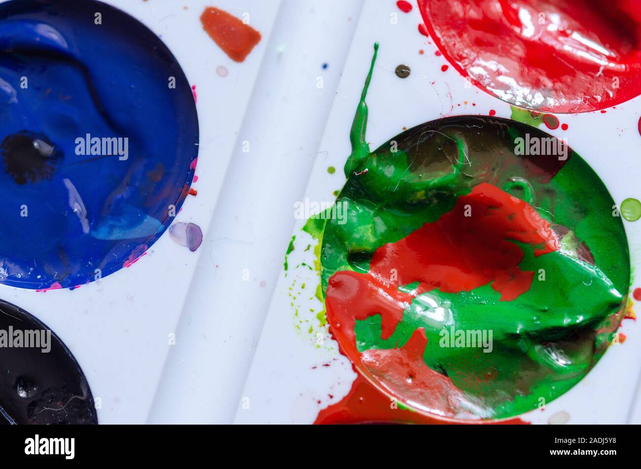 Ein Fleck mit roter Farbe in eine grüne Farbe. Eine Palette von Farben. Moderne Kunst Malen spritzen. Bunte curl. Stockfoto