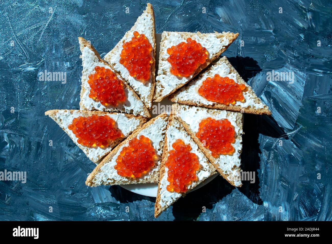 Platte des Schwarzen Brot mit rotem Kaviar auf grauem Hintergrund. Roter Kaviar Sandwiches. Gesundes Essen. Stockfoto