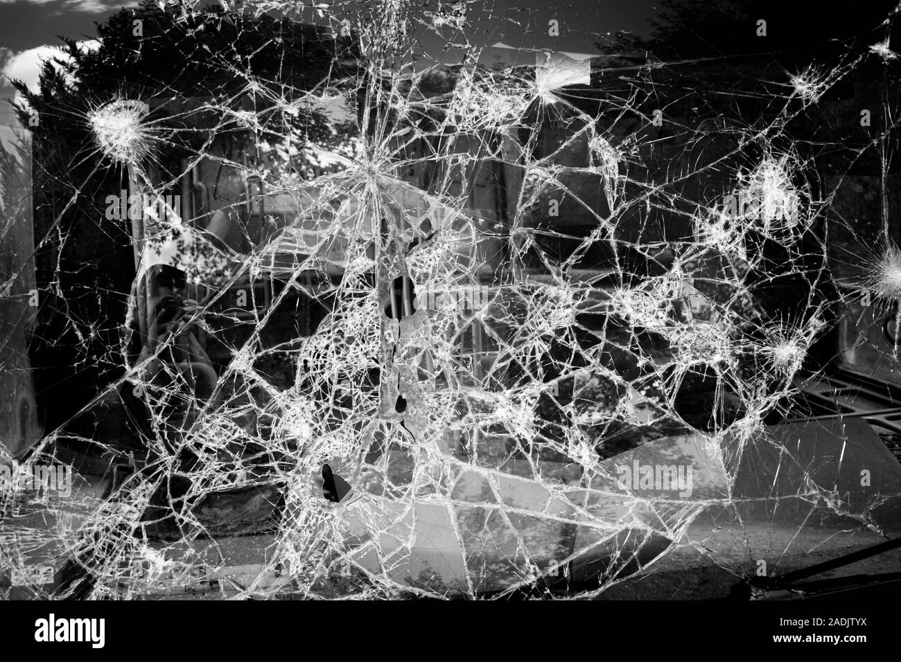 Nahaufnahme von zerbrochenem Glas. Defekter Bildschirm unschärft. Zerschmetternde Glasscheiben. Auto windsiled gebrochene Textur. Weichfokus. Stockfoto