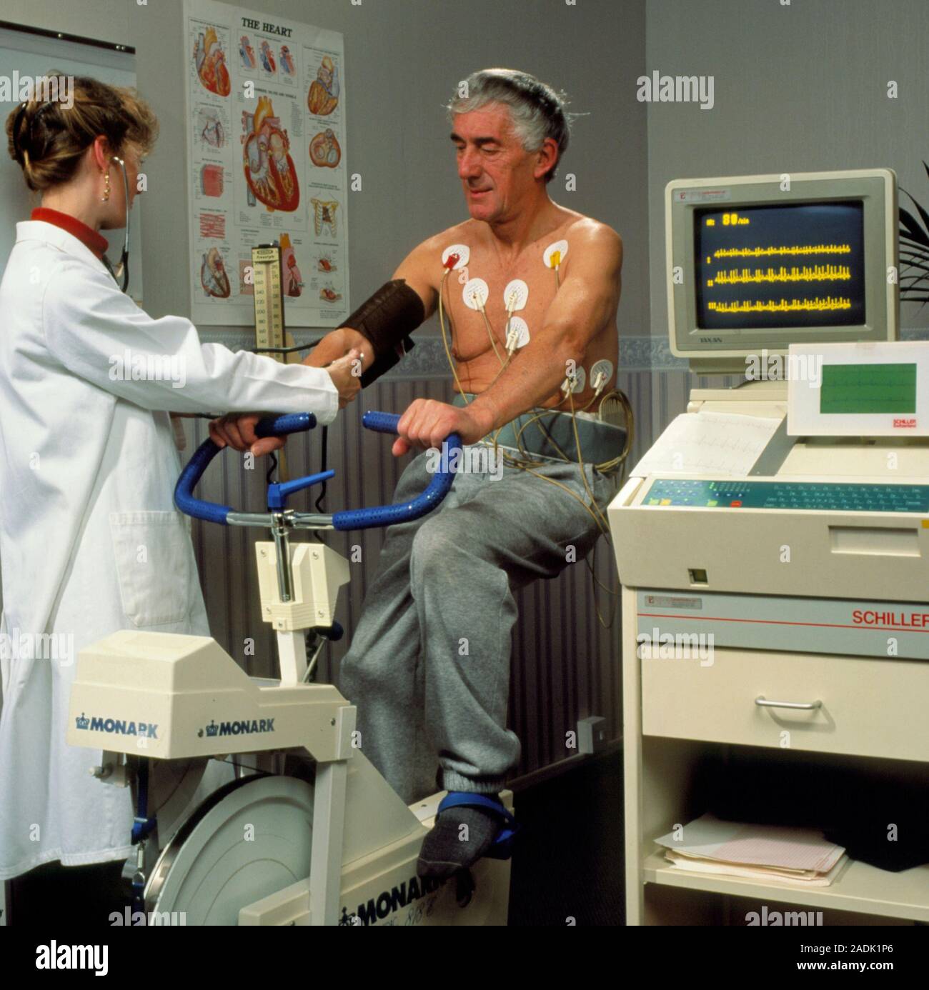 Elektrokardiogramm (EKG) Stress. Eine ältere männliche Herzpatienten  Übungen auf einem Fahrrad, während der EKG-Maschine (rechts) seinen  Herzschlag Maßnahmen. Ekg-stres Stockfotografie - Alamy