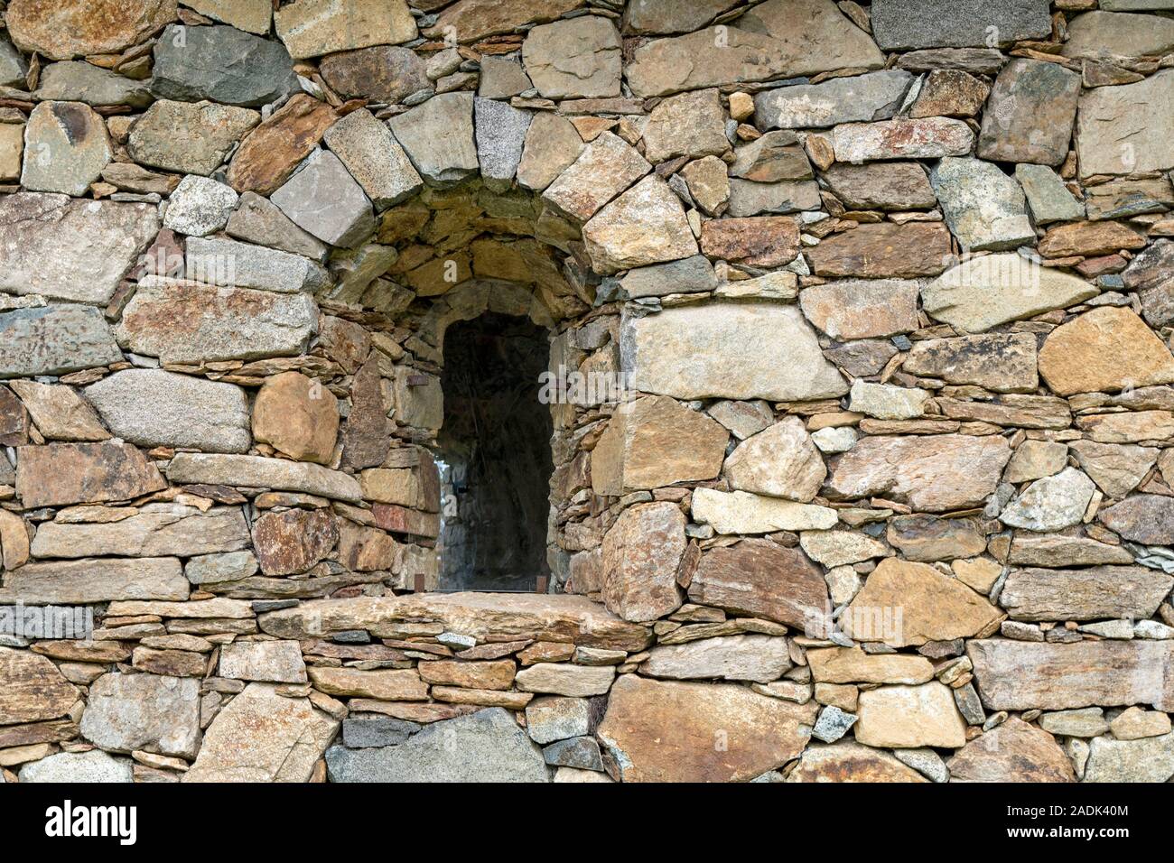 Bogenförmige Fenster in der Mauer aus Stein Stockfoto
