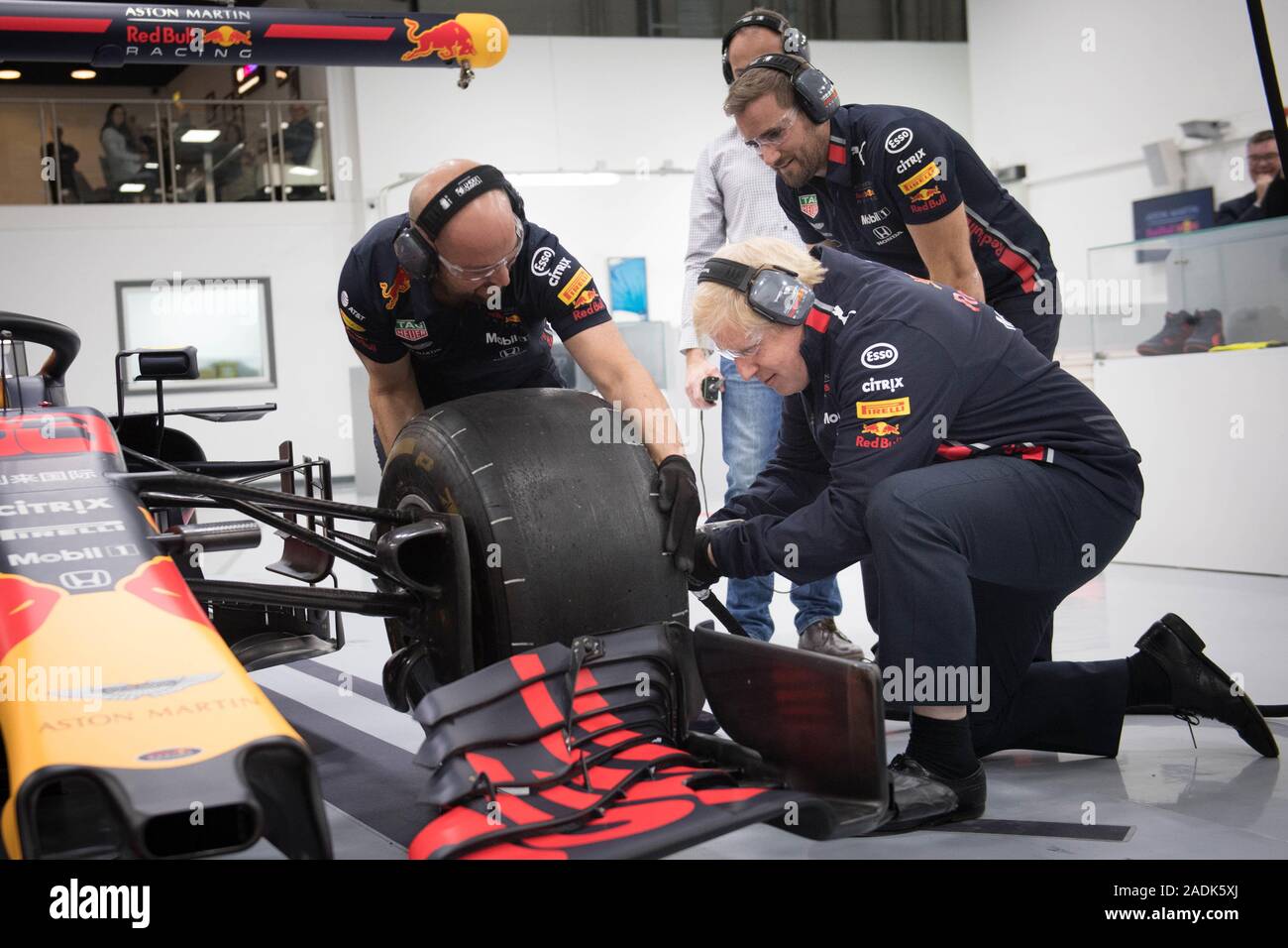 Premierminister Boris Johnson versucht, ein Rad von einem Formel-1-Auto bei einem Besuch bei Red Bull Racing beim Wahlkampf in Milton Keynes, vor der Wahl zu ändern. PA-Foto. Bild Datum: Mittwoch, 4. Dezember 2019. Siehe PA Geschichte Politik Wahl. Foto: Stefan Rousseau/PA-Kabel Stockfoto