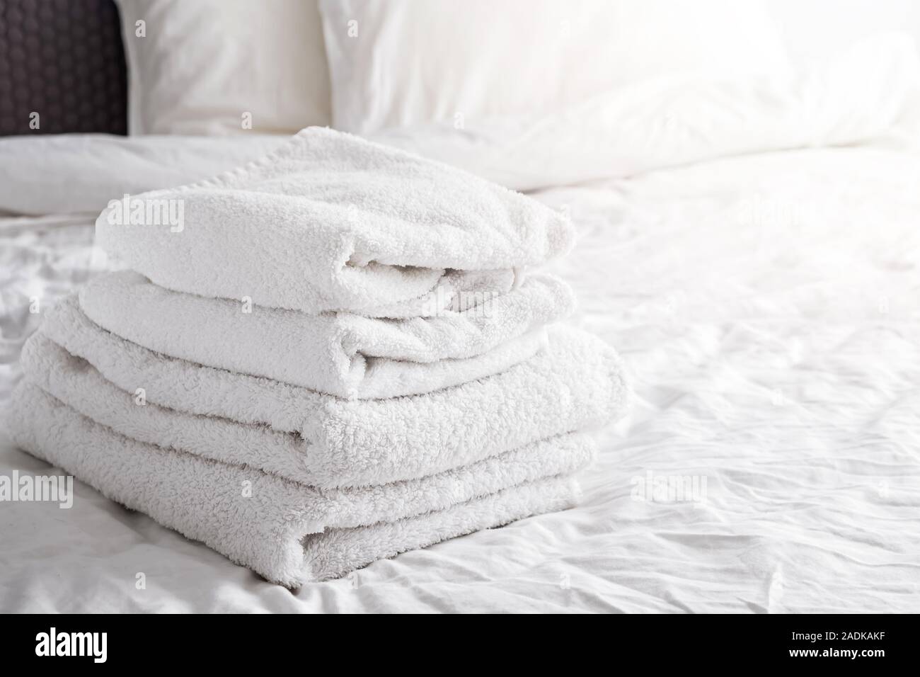 Saubere, weiße Handtücher auf dem weißen Bett Stockfoto