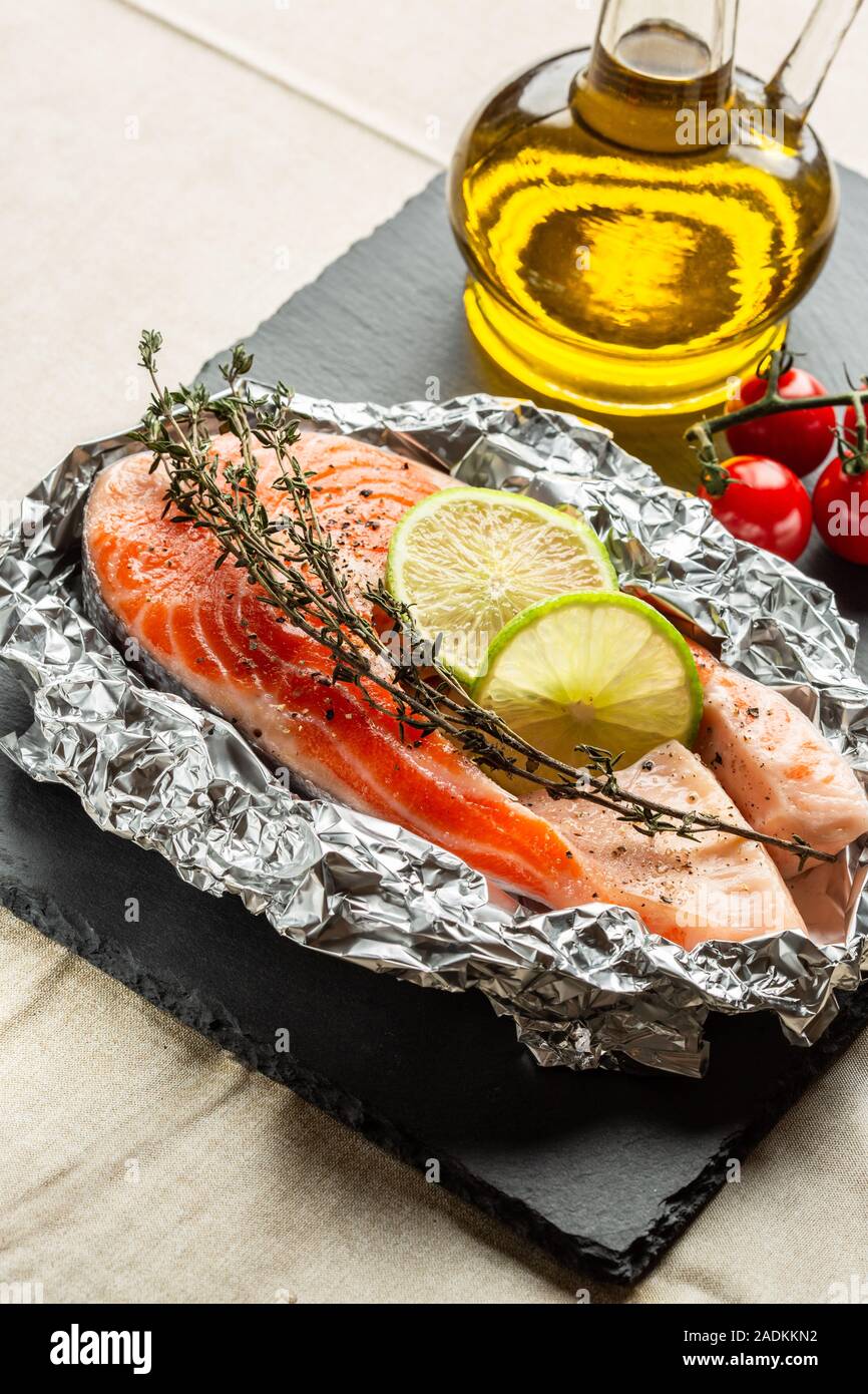 Rohe rote Fische mit Kalk und Thymian auf der Folie Stockfoto