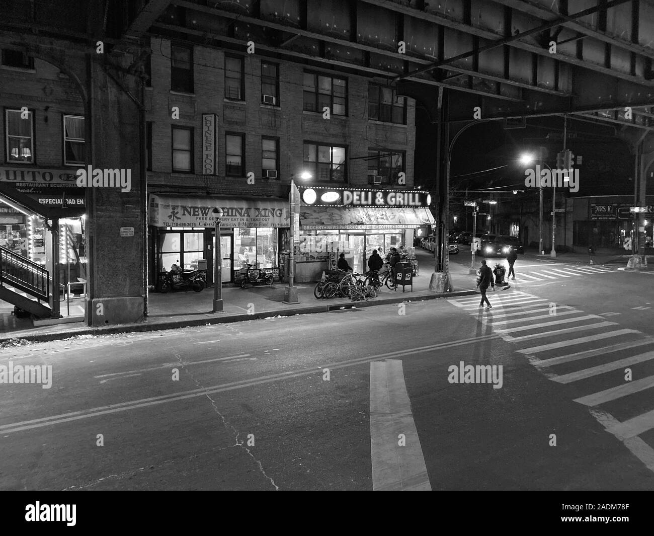 Nacht auf der New Utrecht Avenue unter den erhöhten U-Bahngleisen im Stadtteil Borough Park in Brooklyn, New York. Stockfoto