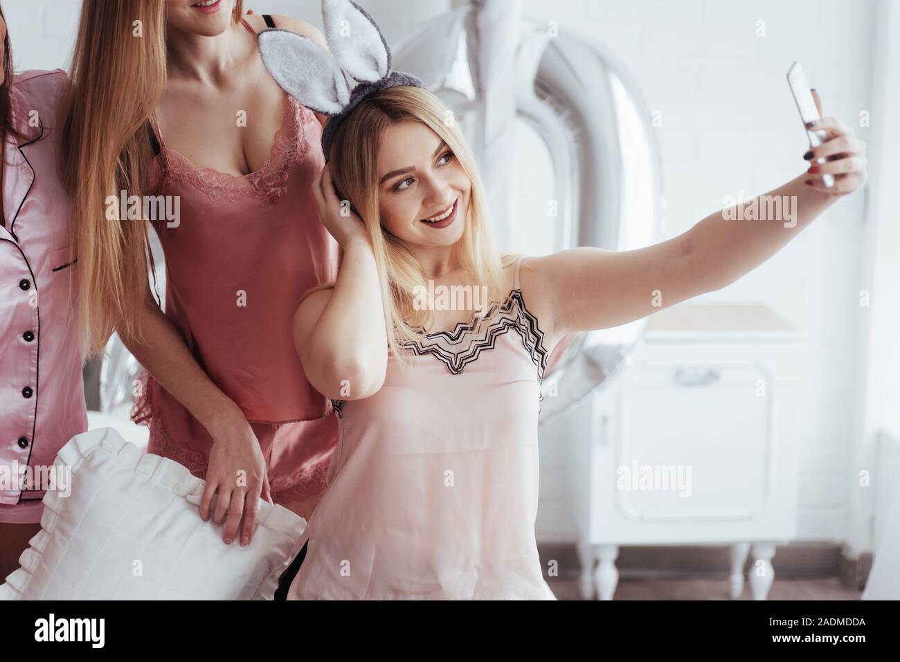 Mädchen schlägt selfie mit ihren Freunden an Bachelorette Party im weißen Zimmer Stockfoto