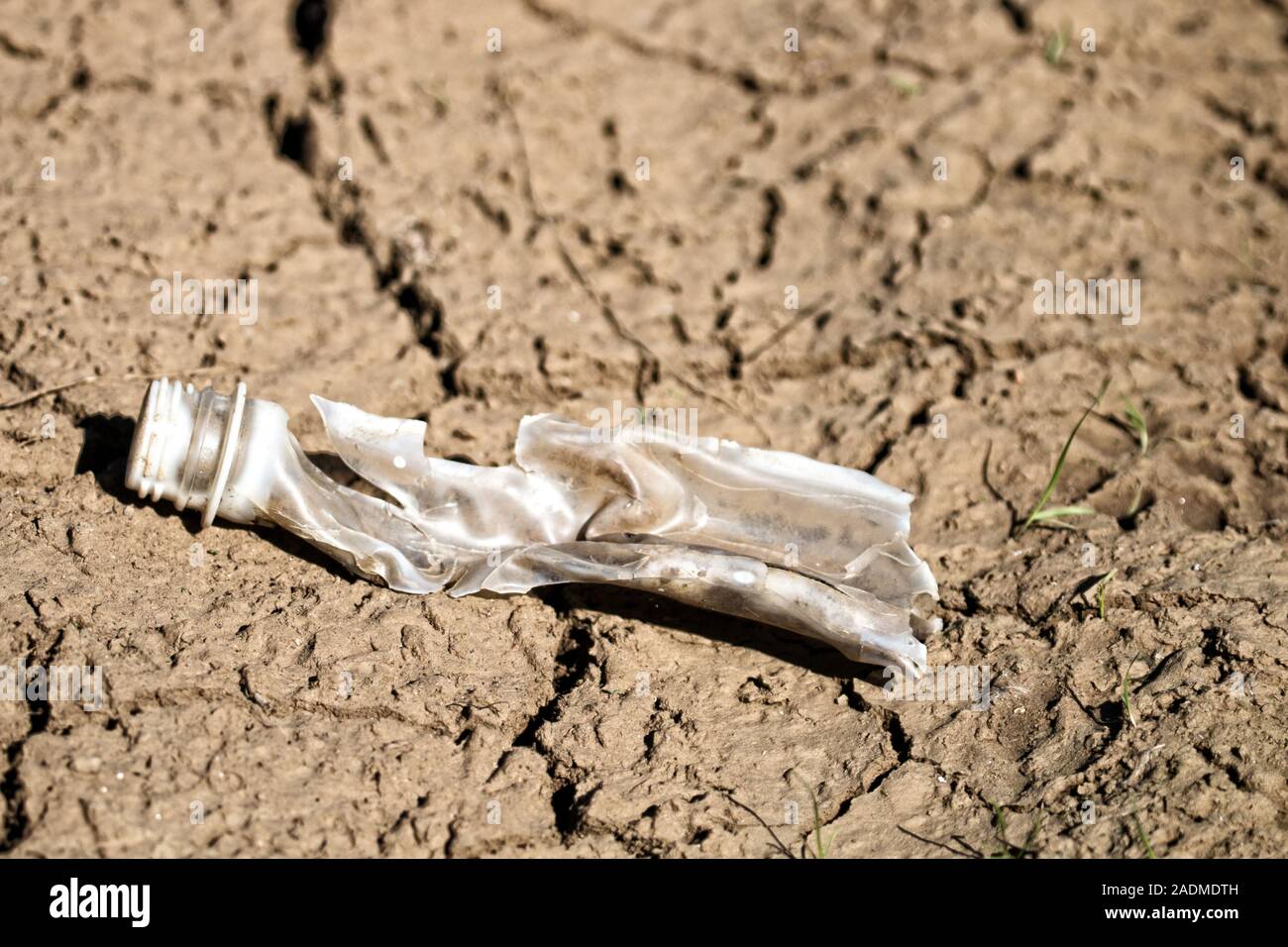 Kunststoff Flasche auf dem Schlamm Bank die Hälfte brach von der Sonne und mechanische Einwirkungen Stockfoto