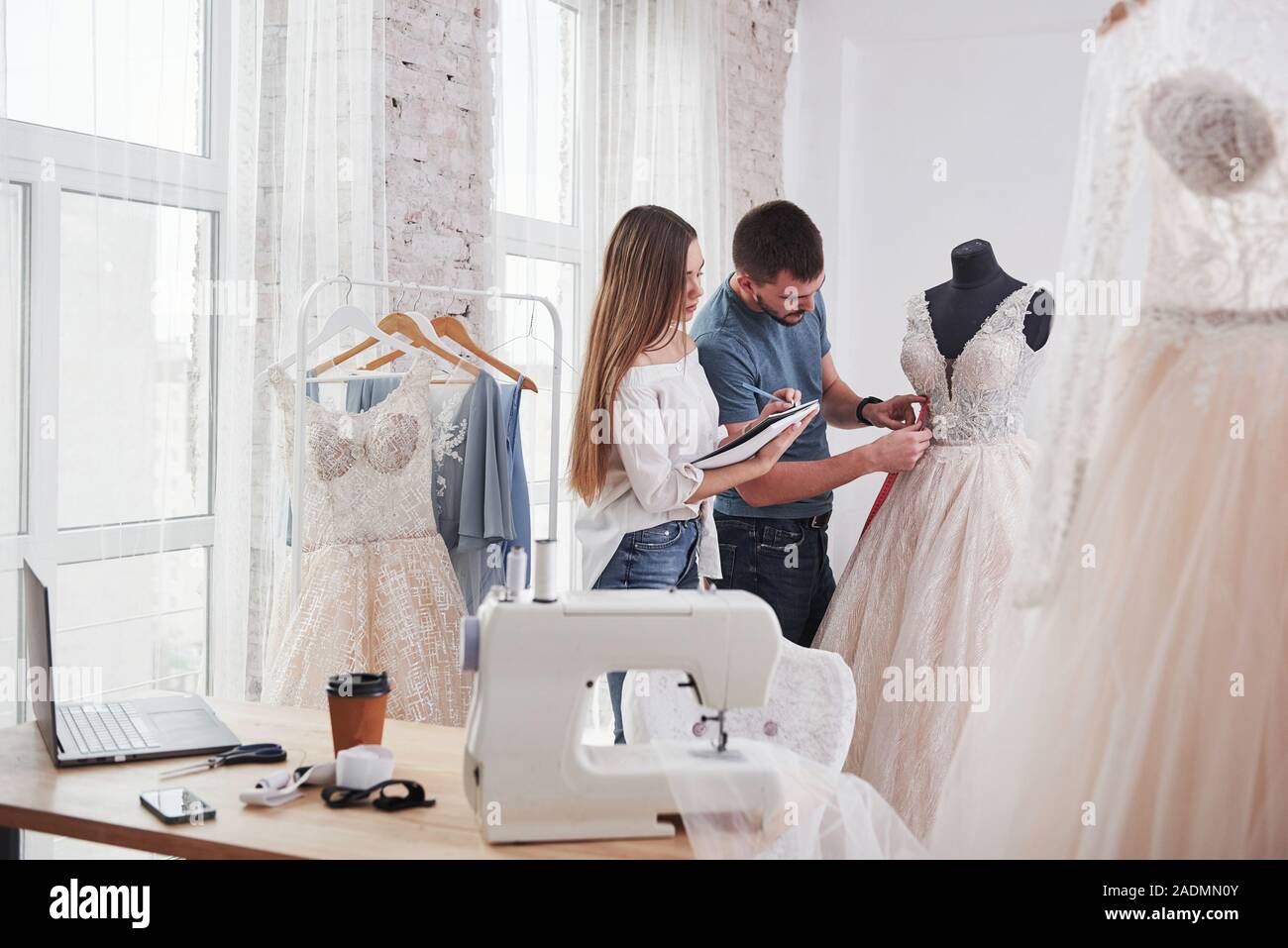 Notizen in das Schulbuch. Der Prozess der Montage das Kleid im Studio von Hand gestaltete Kleidung Stockfoto