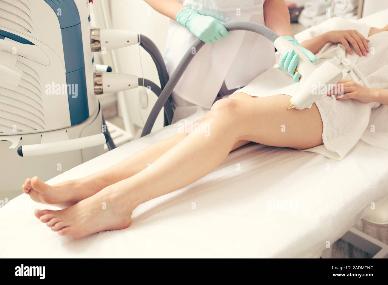 Beine der Jungen Dame und medizinischer Arbeiter Berühren mit modernen Werkzeug Stockfoto