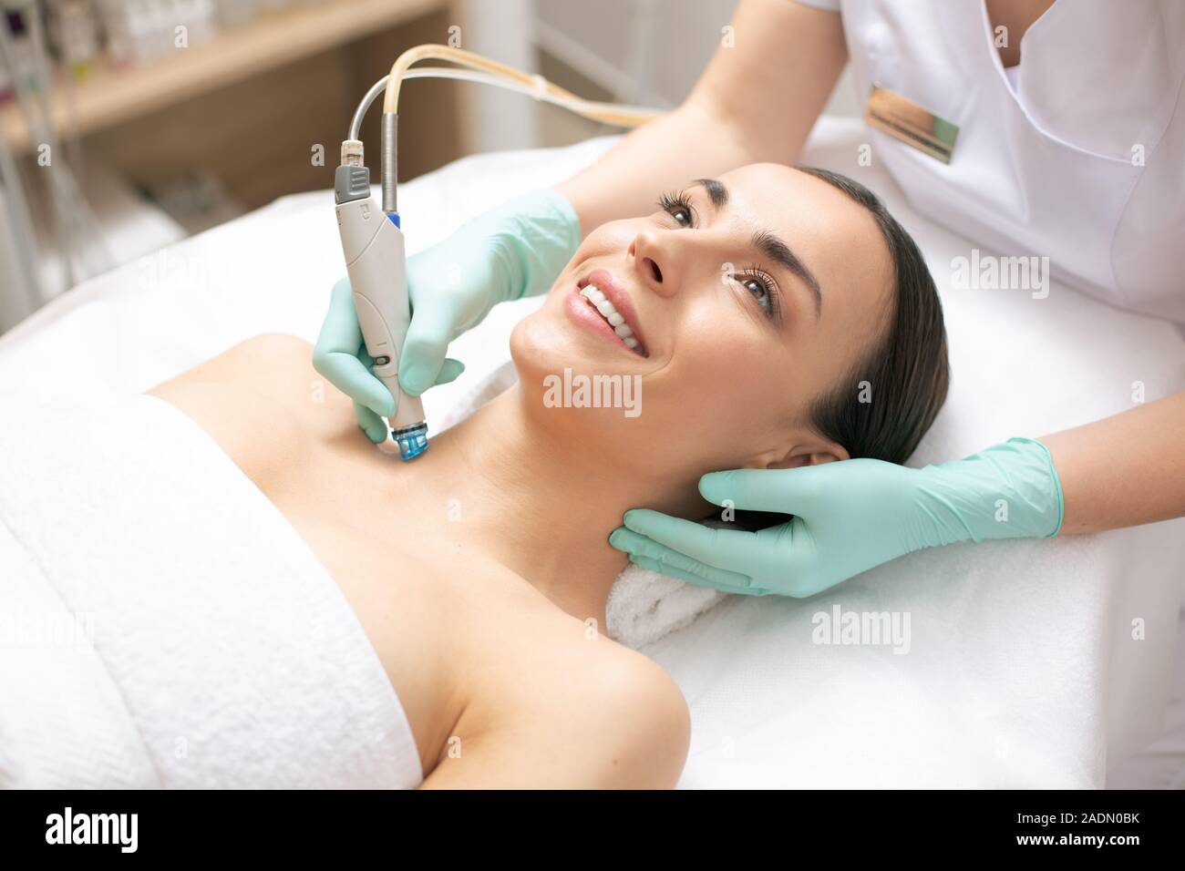 Gerne Frau, dermabrasion Verfahren der Haut ihres Halses Stockfoto