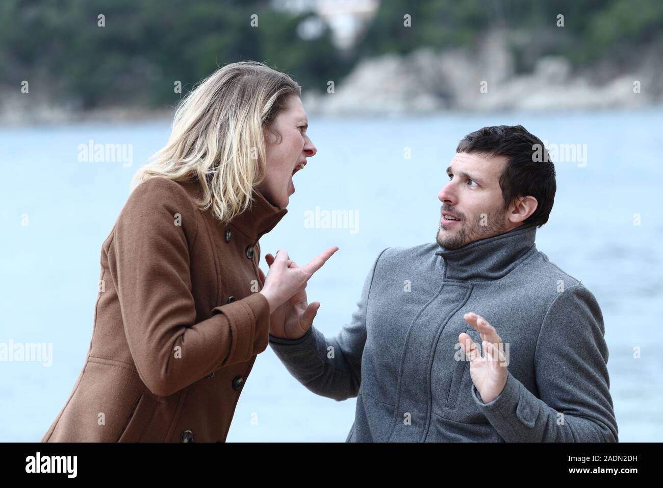 Wütende Frau schreien zu ihrer Angst Mann am Strand Stockfoto