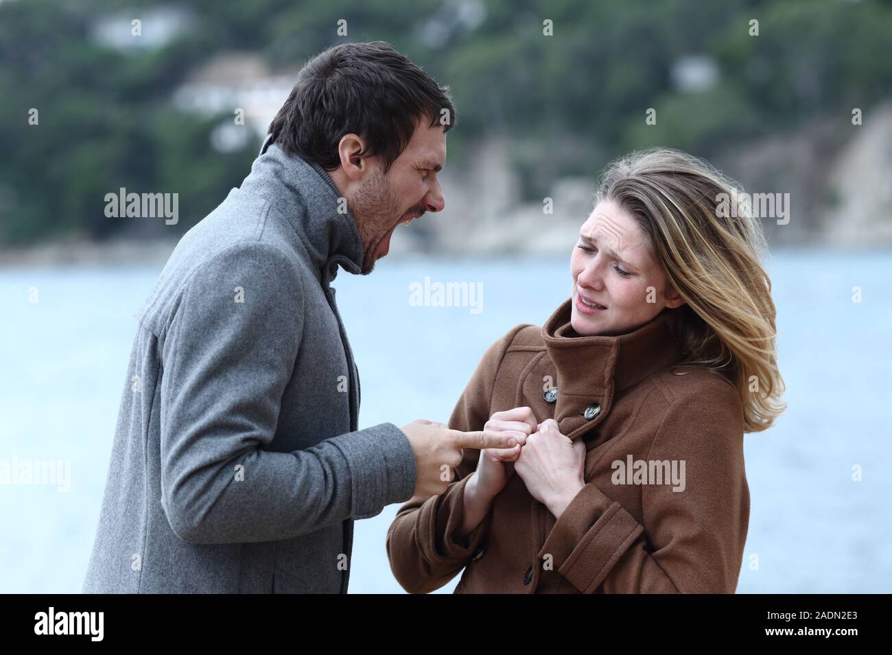Zornigen Mann schreien zu Angst Frau im Winter am Strand Stockfoto