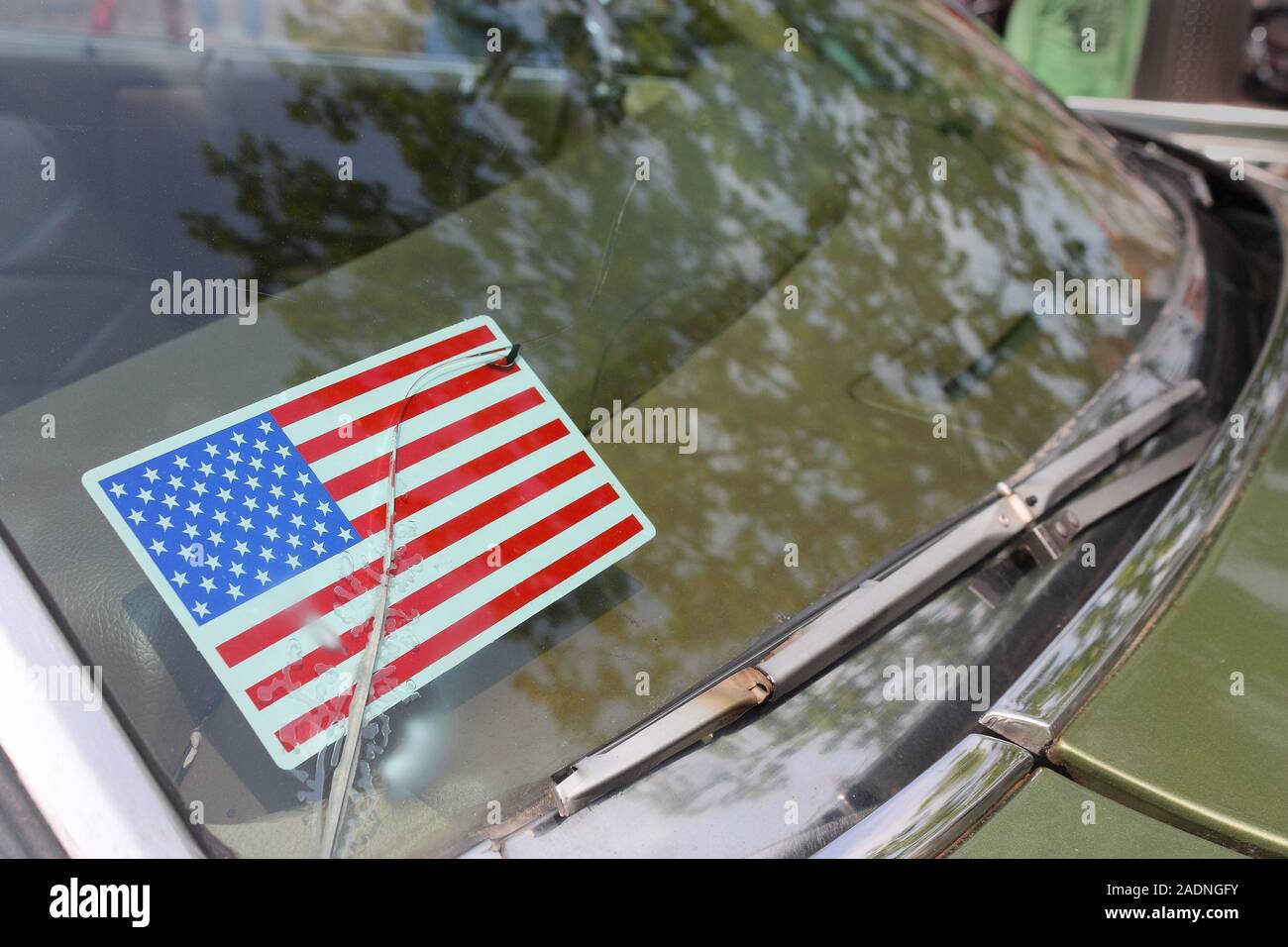 Aufkleber der amerikanischen Flagge hinter gesprungene Frontscheibe eines grünen retro Auto Stockfoto