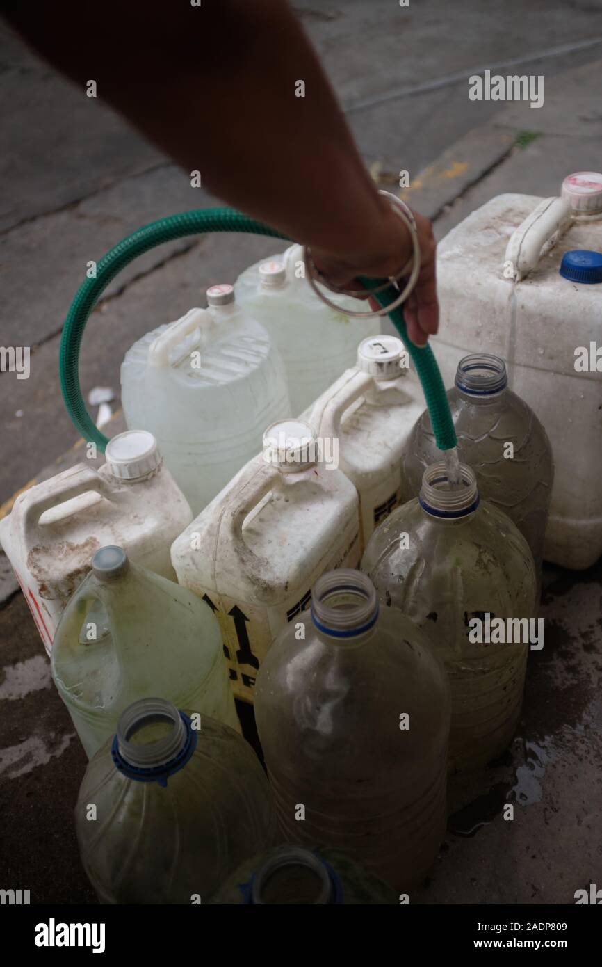 Caracas, Miranda, Venezuela. 29 Nov, 2019. Aura befüllen das Wasser contaners mit dem Wasser aus dem Haus ihrer Schwester. Aura Graciela Sarmiento, Alter 56, und ihr Mann Jose Alberto Abreu, Alter 62, habe keine fliessendes Wasser in Ihrem Haus in 4 Jahren. Aura arbeitet in ein Geschäft mit Büromöbeln und Jose ist ein Mechaniker. Sie leben in der Nähe von Altos de Lidice in Caracas Venezuela. Altos de Lidice ist ein historisches Chavista Nachbarschaft. Aber Aura ist pro-Opposition, und hat nie die Chavez Regime unterstützt, obwohl sie in diesem pro lebten - Chavez/Maduro barrio ihr ganzes Leben. S Stockfoto