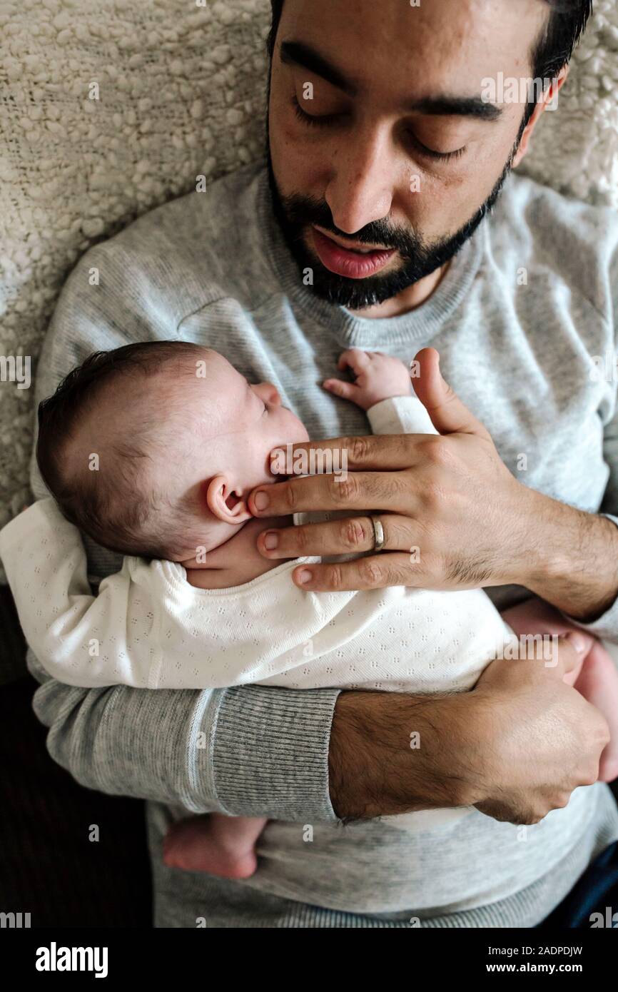 Liebevoller Vater mit Vollbart sanft berührt von schlafen Neugeborene Stockfoto