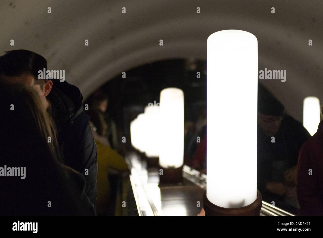 Moskau. Russland. 10.04.2019. Abstieg in die U-Bahn. Die Menschen auf der Rolltreppe. U-Bahn hell leuchtet. Stockfoto