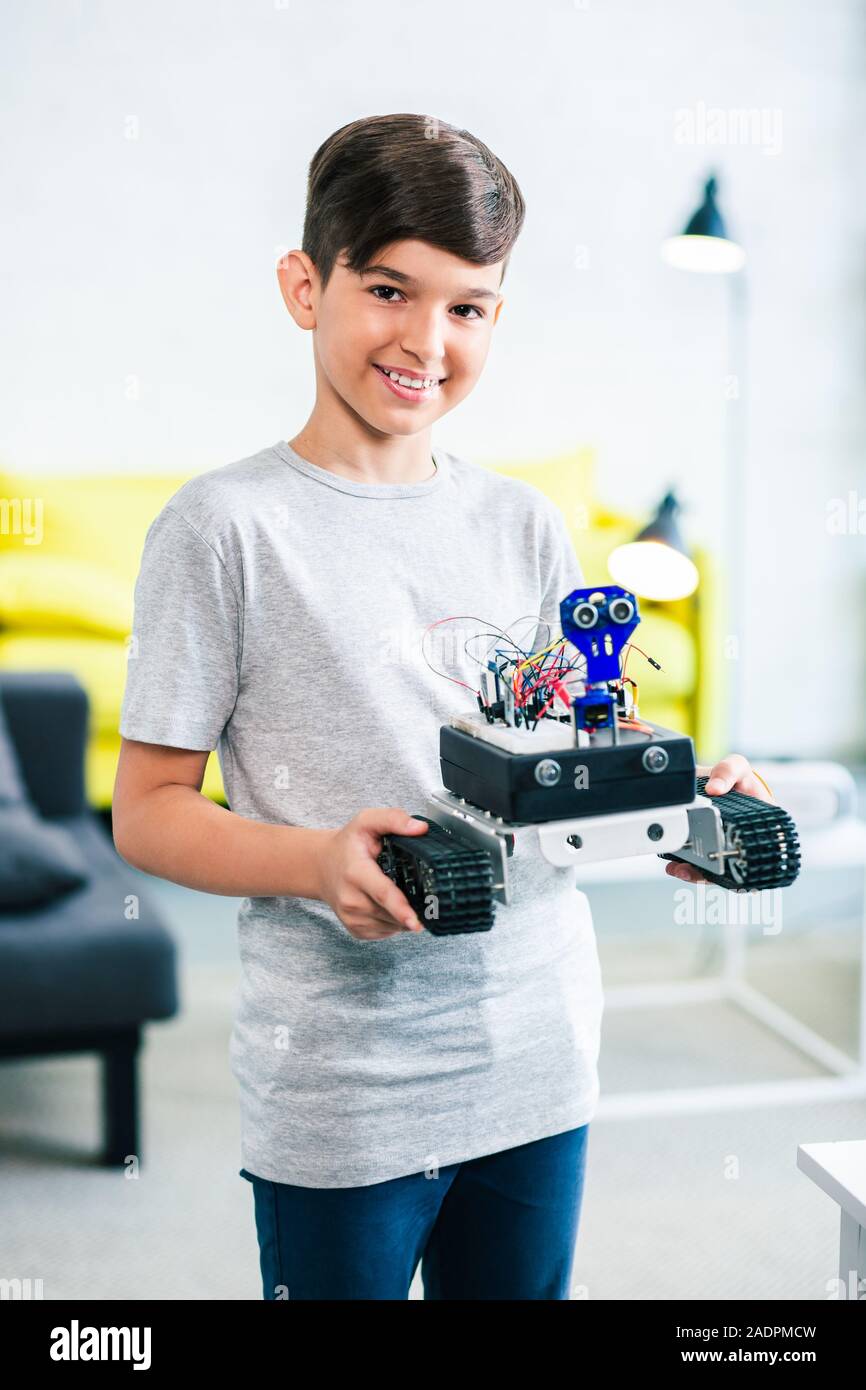 Optimistisch smart Junge seinen modernen Roboter Holding Stockfoto