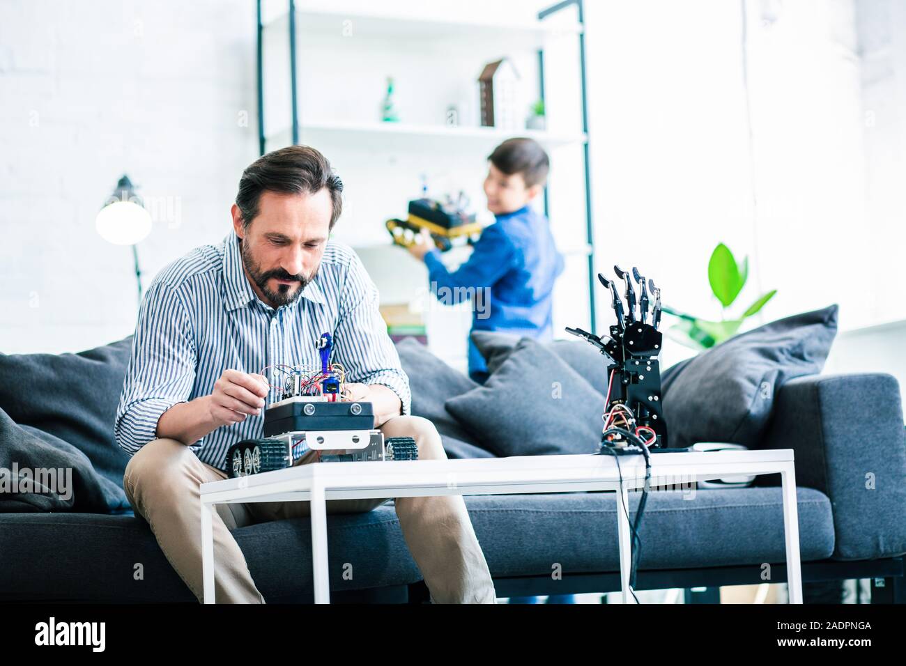 Intelligenter Mann, indem er einen Roboter erfreut Stockfoto