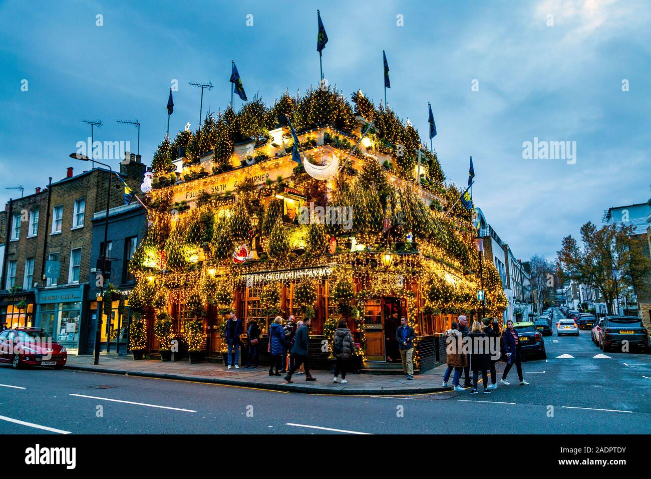 Opulente Weihnachtslichter und Dekorationen an der Fassade des Churchill Arms Pub, London, Großbritannien Stockfoto