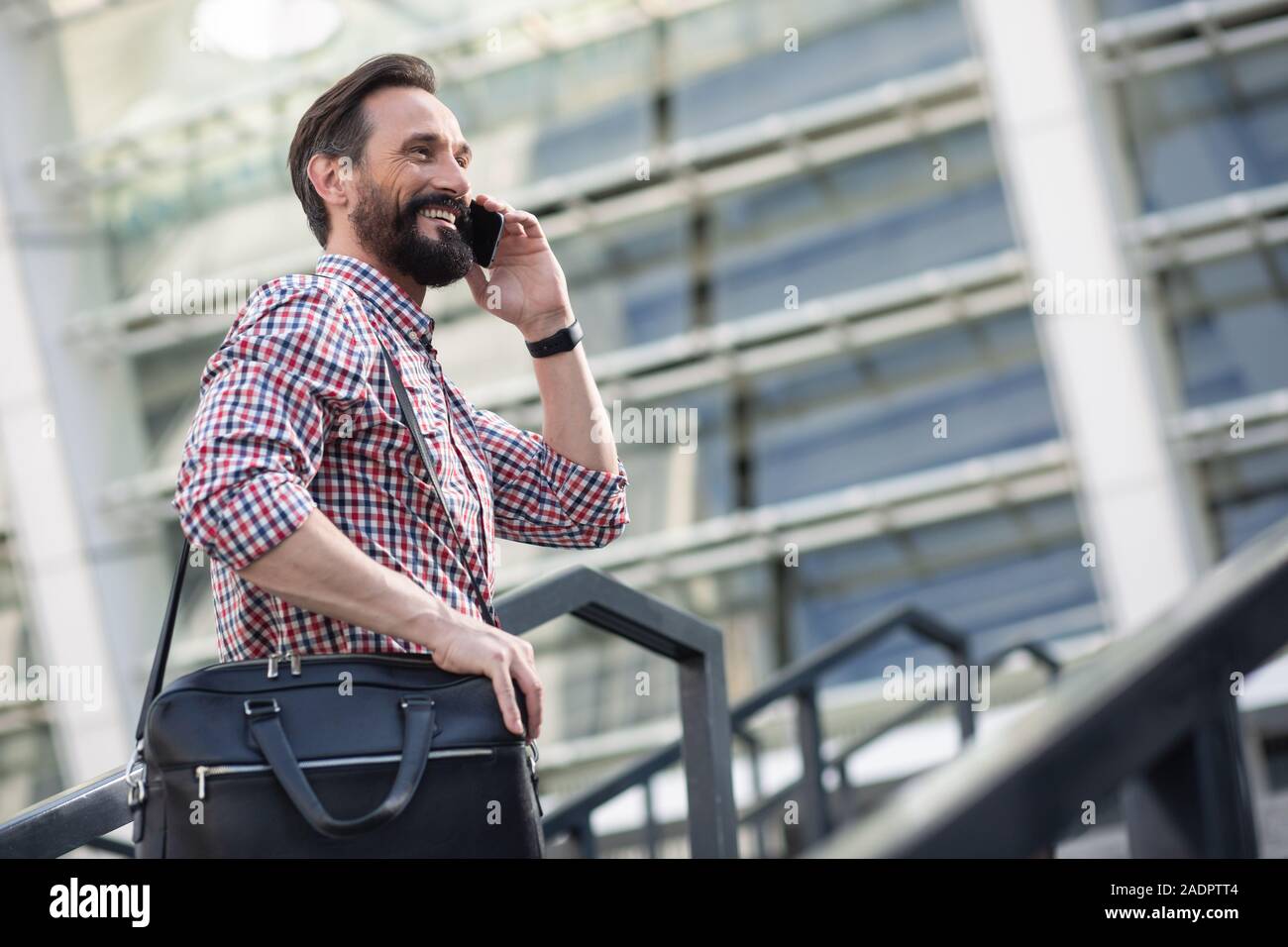 Positive Mann, der eine Tasche auf der Straße Stockfoto