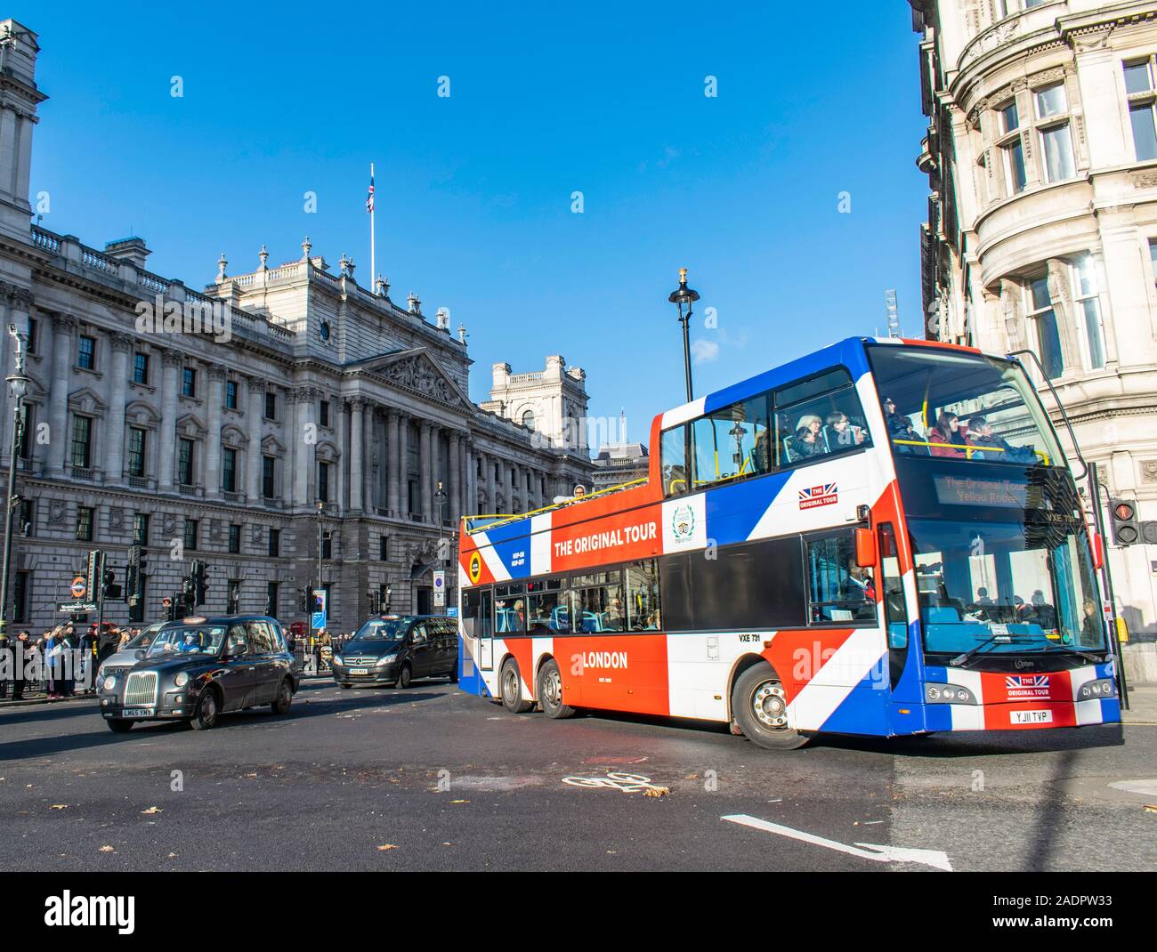 Die 'Original Tour Bus oben offenen sightseeing tour bus nähert sich die Westminster Bridge mit Touristen über die schwarzen Londoner Taxis und. Stockfoto