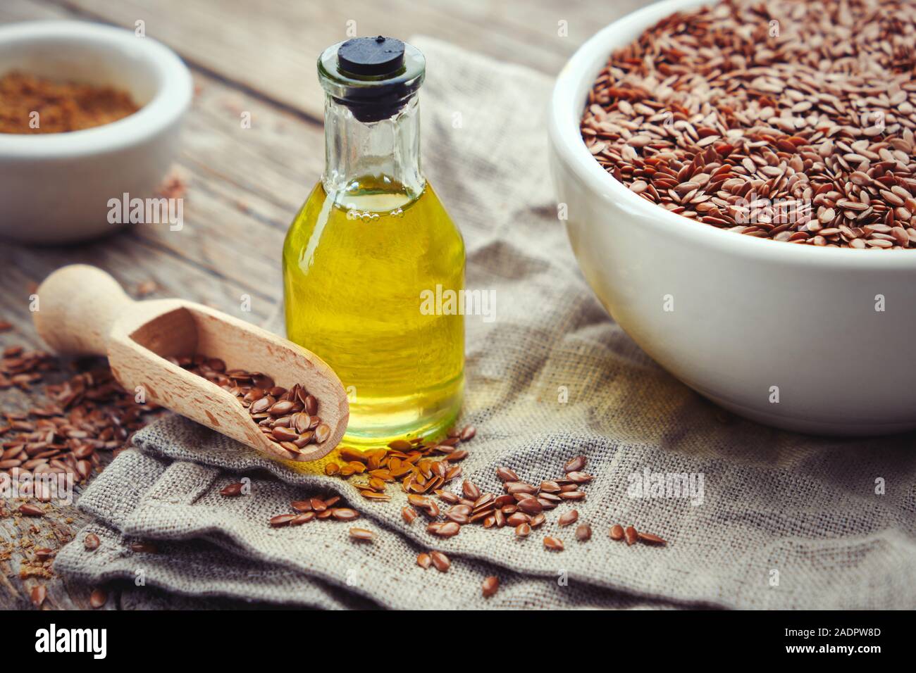 Mörtel von Leinsamen und eine Flasche frisches Leinöl auf Leinen. Stockfoto