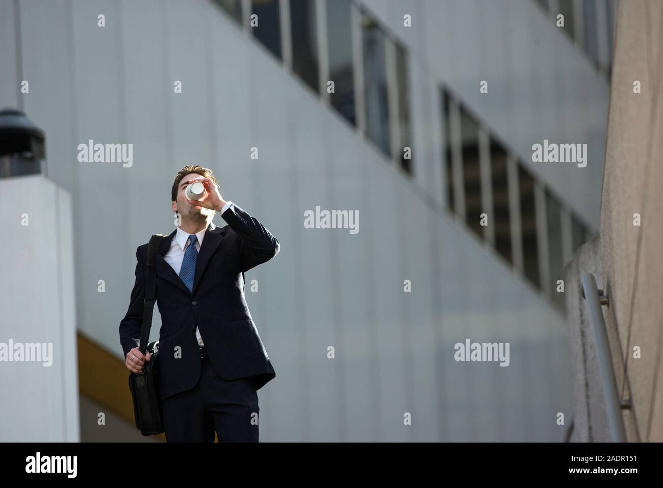 Zuversichtlich Geschäftsmann schreitende Arbeit mit seinen Kaffee am Morgen Stockfoto
