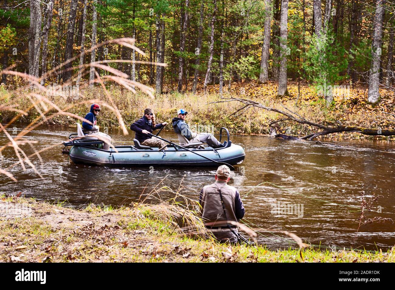 Waten fischer Uhren als float Boot übergibt die Pere Marquette River in der Nähe von Walhalla, Michigan, USA fliegen. Stockfoto