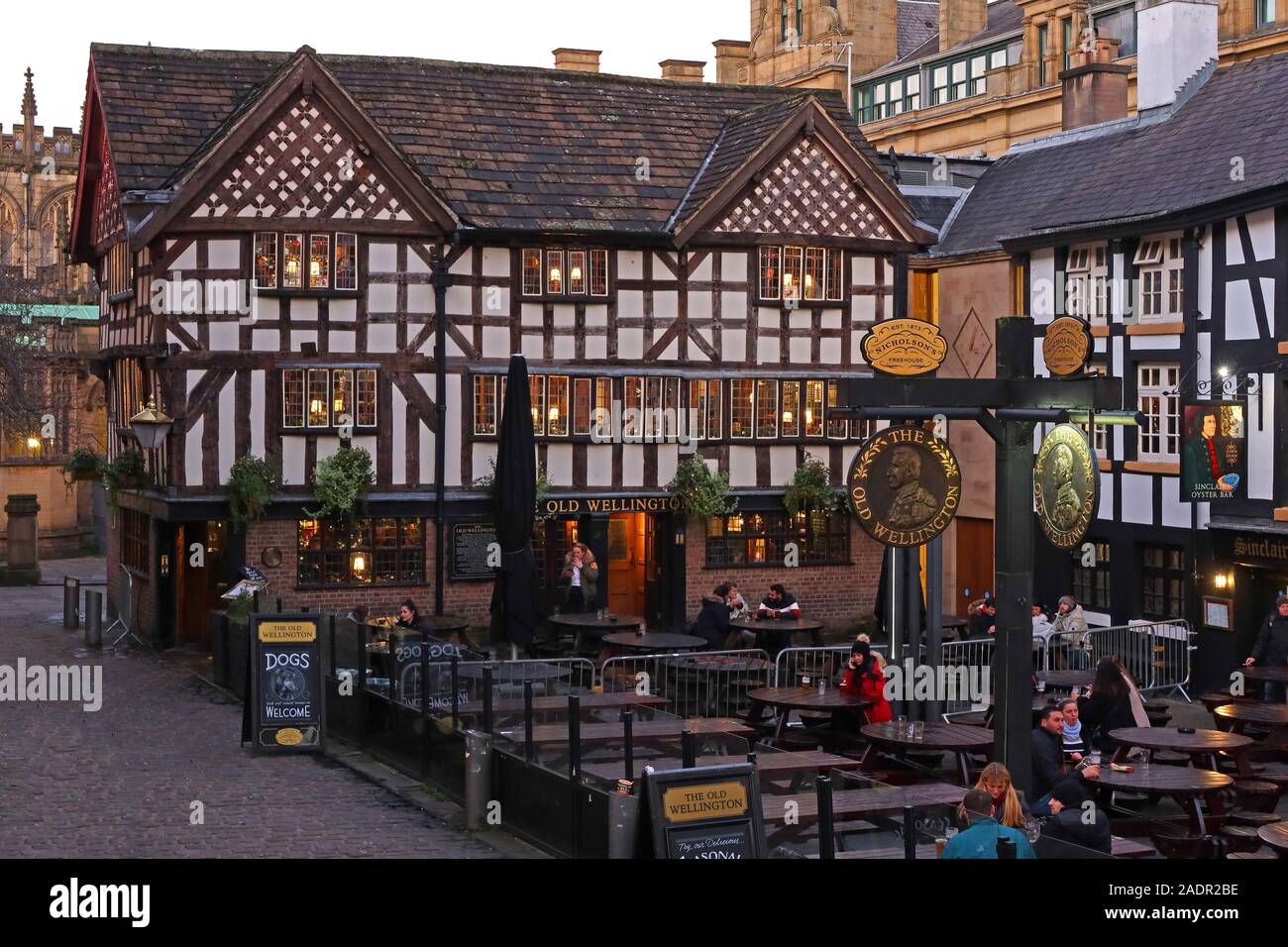 The Old Wellington, Fachwerk, Pub aus dem Jahr 1552, antikes Denkmal, 4 Cathedral Gates, Manchester. In der Abenddämmerung, Winterzeit. Stockfoto