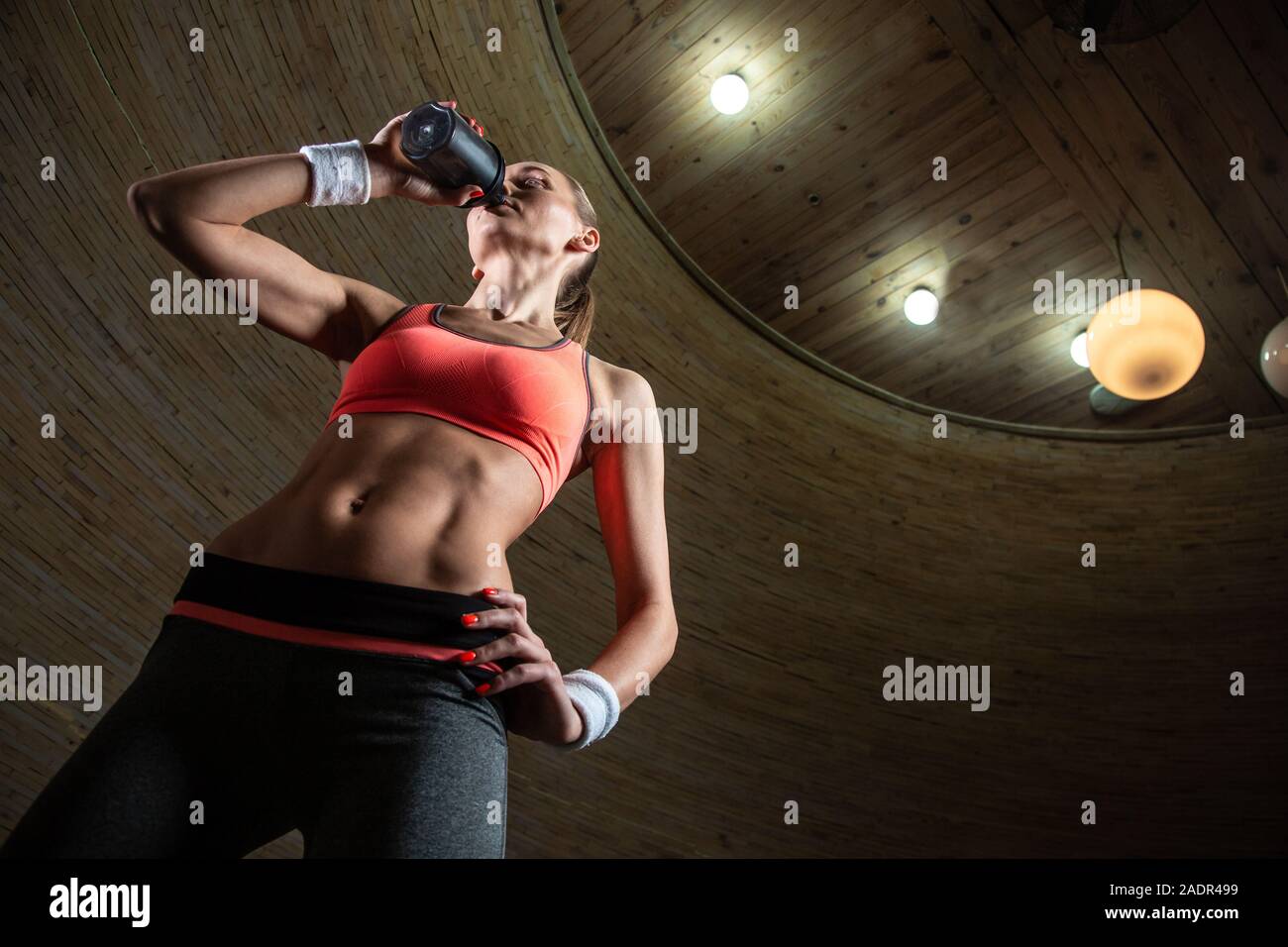 Taille bis sportlich Frau trinkt Wasser aus sportlichen Flasche Stockfoto