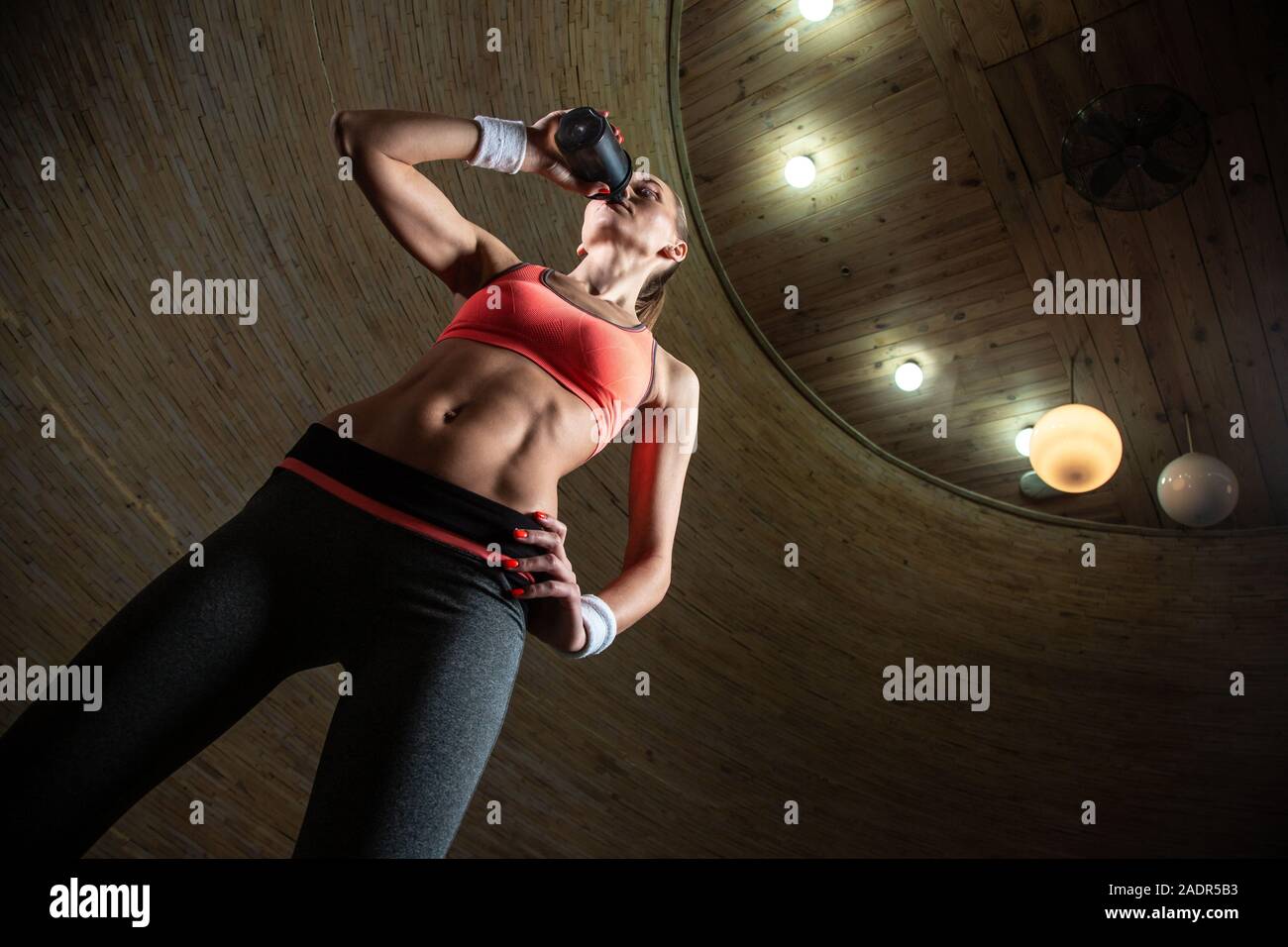 Taille bis attraktive schlanke Dame Trinkwasser von sportlich Flasche Stockfoto