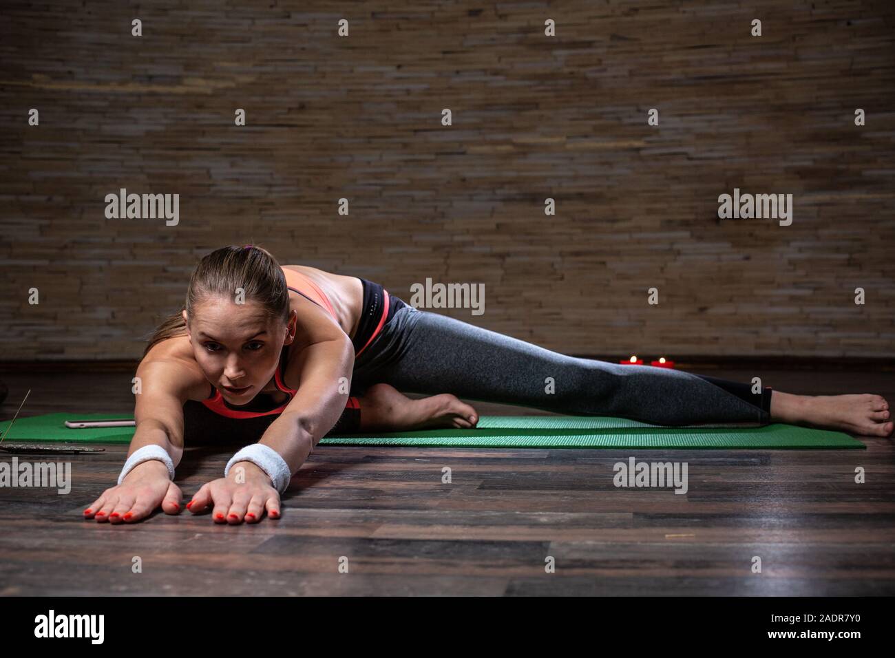 Ruhige junge Dame Yoga und Stretching auf der Yogamatte Stockfoto