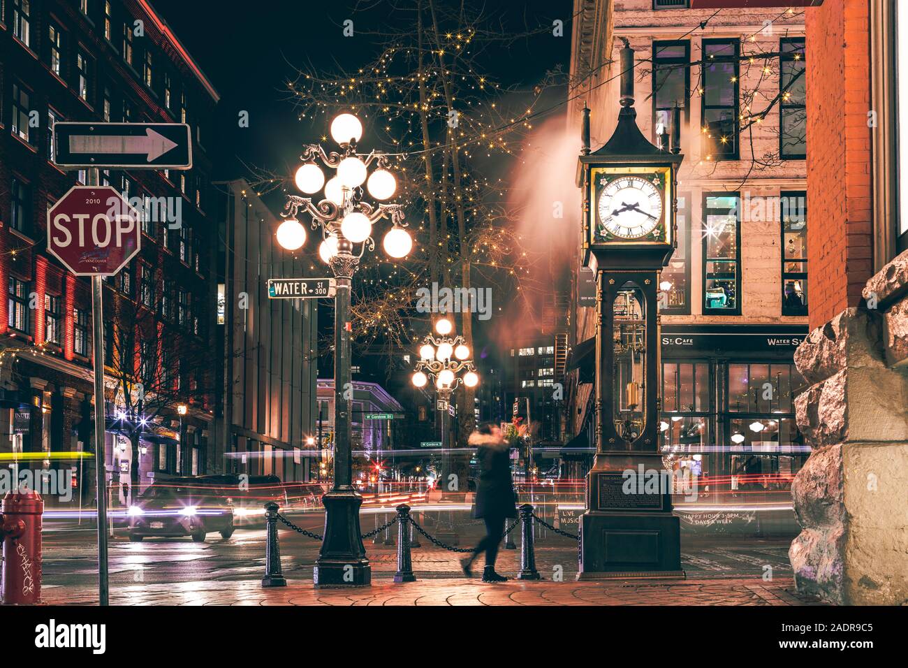 Vancouver, British Columbia - Dez 3, 2019: Der berühmte Steam Clock in Gastown in Vancouver city mit Autos leichte Wanderwege in der Nacht Stockfoto