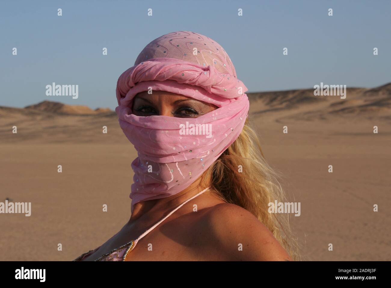 Blonde Frau mit rosa turnban in der Wüste Stockfoto