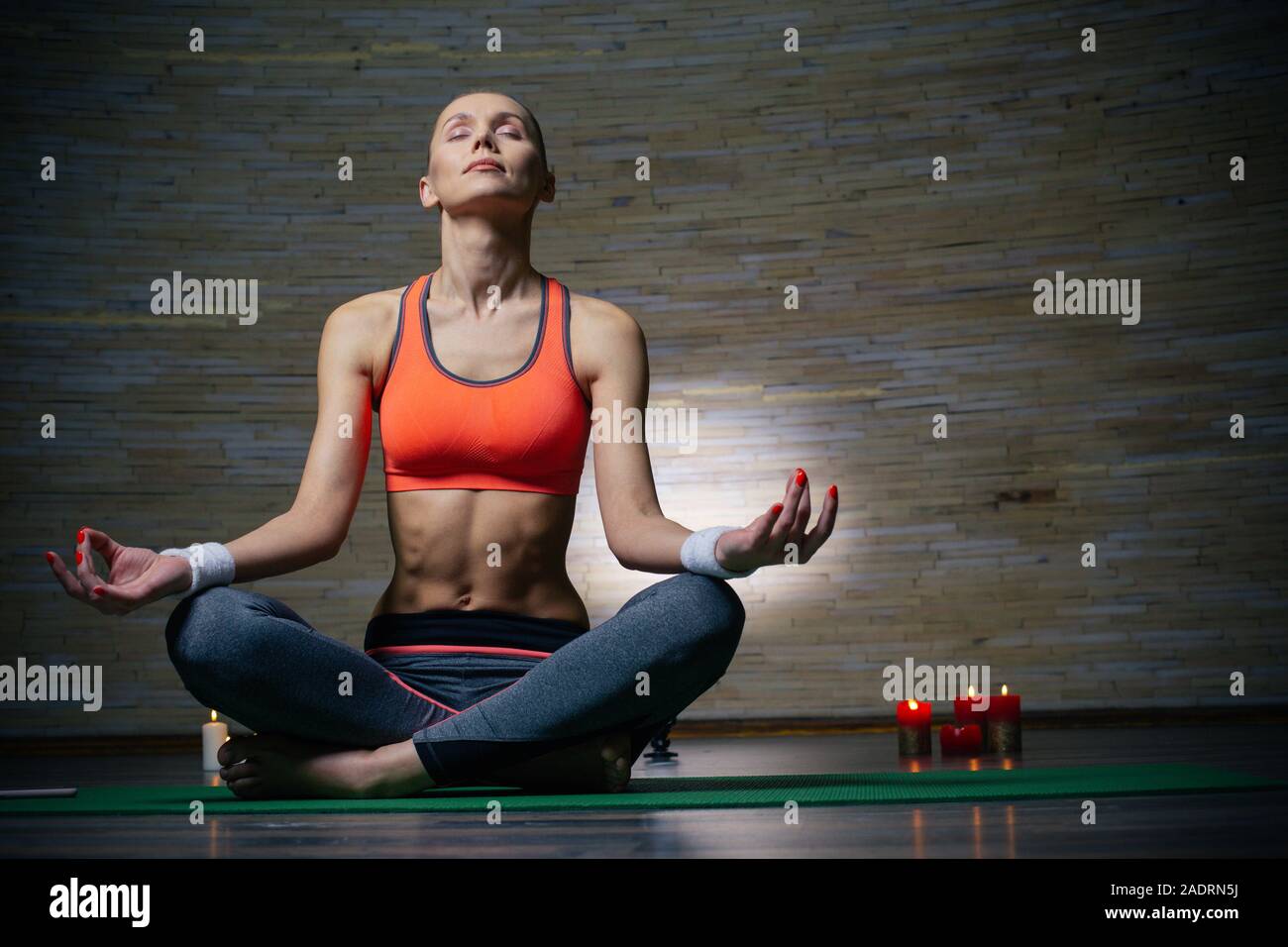 Volle Länge des jungen Dame meditieren im leeren Zimmer Stockfoto