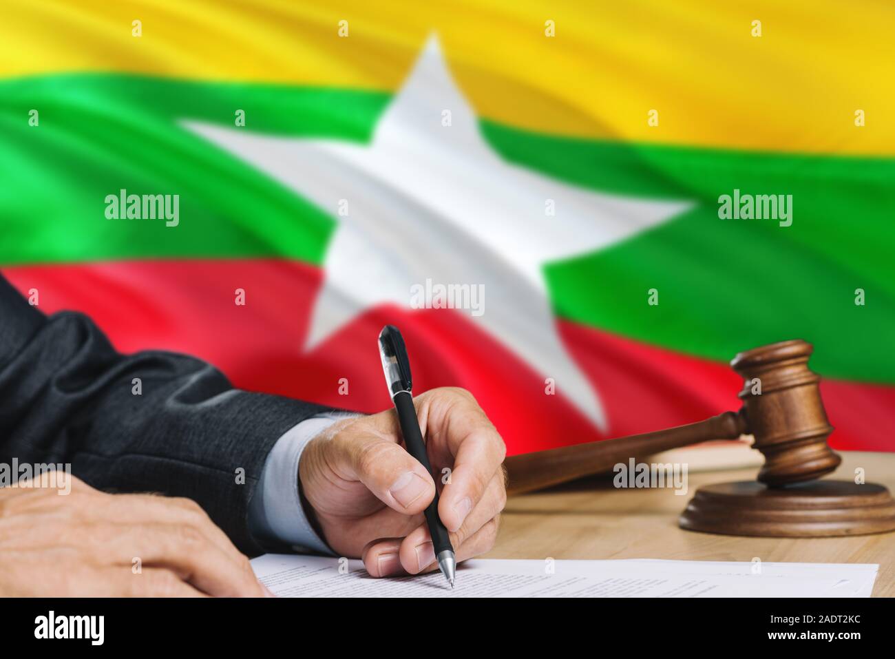 Richter schreiben auf Papier im Gerichtssaal mit Myanmar Flagge Hintergrund. Holz- Hammer der Gleichstellung Thema und rechtlicher Begriff. Stockfoto