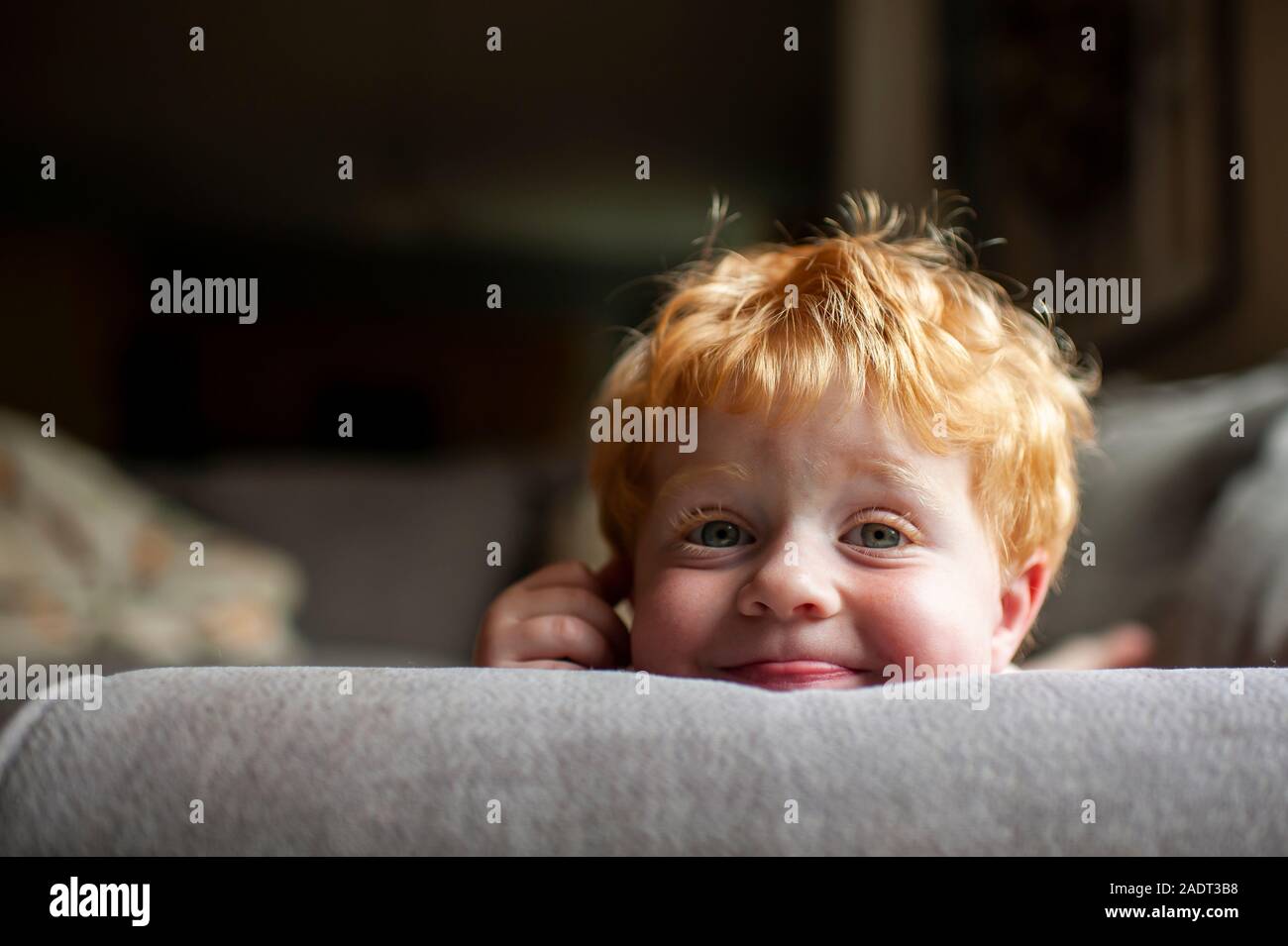 Nahaufnahme der Toddler Boy mit dummen Ausdruck Festlegung auf der Couch zu Hause Stockfoto