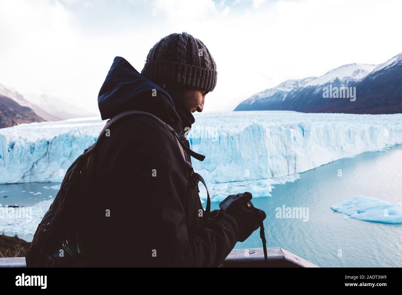 Männliche Reisende seine Kamera Kontrolle in der Nähe der Gletscher an bewölkten Tag Stockfoto