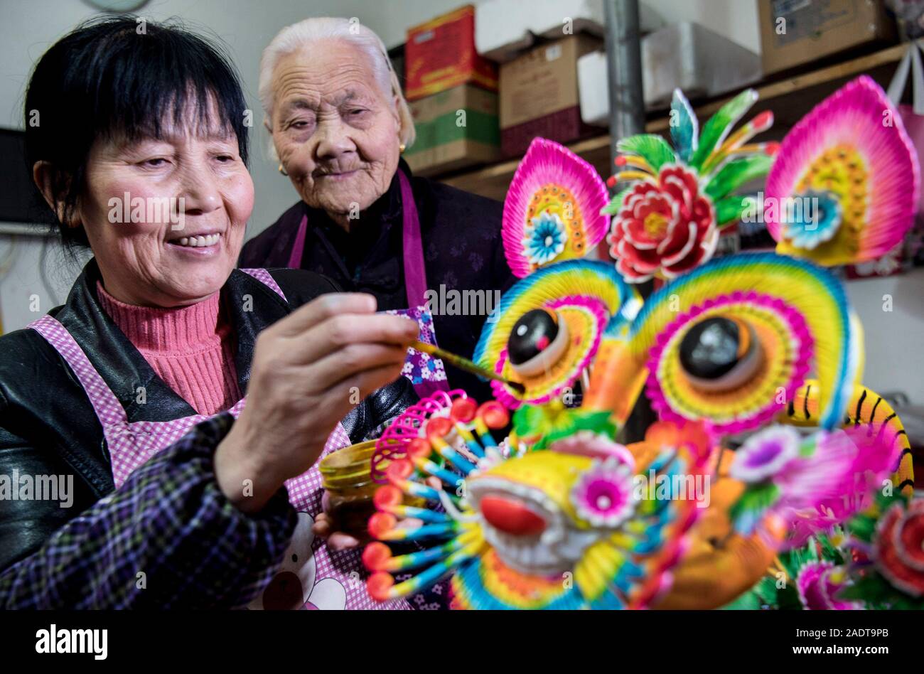 Heyang, Shaanxi Chinas Provinz. 4. Dez, 2019. Folk Künstler Li Jinxian (L) Farben Teig Modellierungen namens 'Huamo' mit ihren 85-jährige Schwiegermutter Dang Funing, berühmt für die Herstellung von Huamo vor Ort, in Kunlong Dorf von Fang County im heyang County im Nordwesten der chinesischen Provinz Shaanxi, Dez. 4, 2019. Li Jinxian, 58-jähriger Dorfbewohner von Kunlong Dorf, hat geerbt und entwickelt die Fähigkeiten der Teig Modellierungen für Dutzende von Jahren und war Provinzial ausgezeichnet-Handwerk Meister Titel für ihre Fähigkeiten. Credit: Tao Ming/Xinhua/Alamy leben Nachrichten Stockfoto